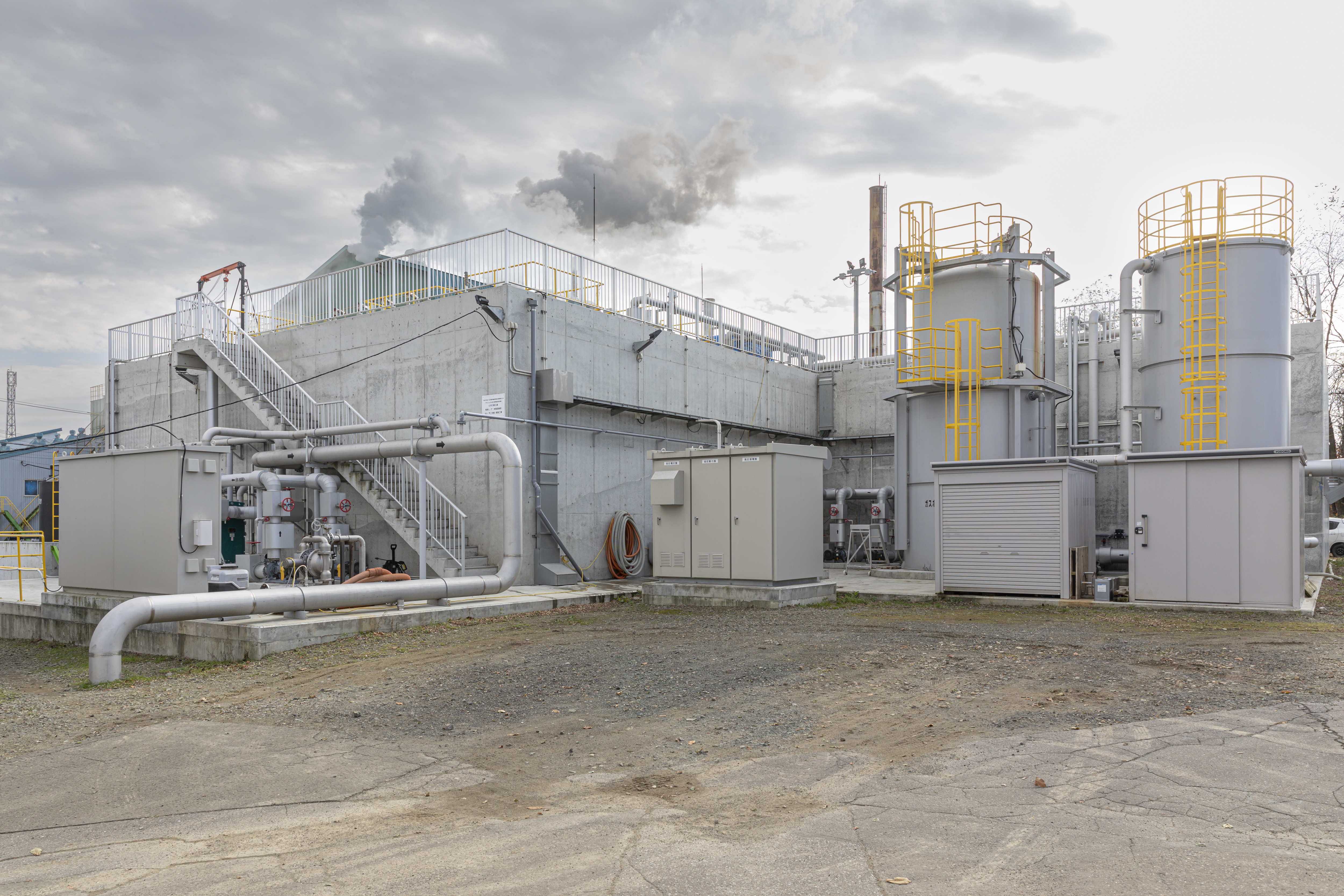 The biogas produced during methane fermentation is harnessed as fuel to create the heat that drives the anaerobic process. The cylindrical tank on the right is a desulfurization tower, and the left stores gas.